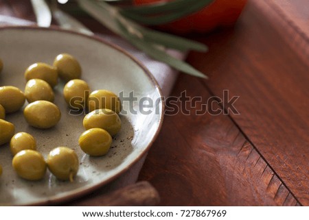 Fresh green olives on the rustic plate