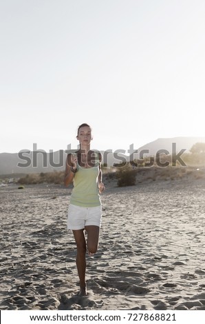 Athletic young woman running in the nature. Healthy lifestyle. Vertical photo.