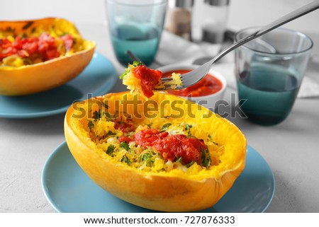 Fork with baked flesh and stuffed spaghetti squash on table Royalty-Free Stock Photo #727876333