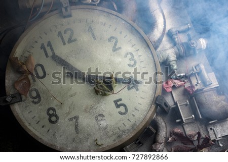 Large wall clock on the table with details and smoke