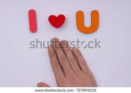 I love you. Words from wooden letters on light grey background. Cute valentine day card