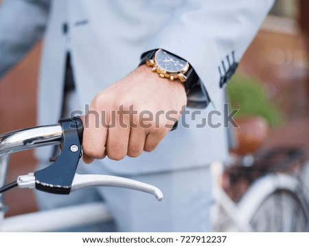 A young stylish businessman going to work by bike outdoors.