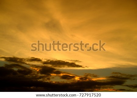 Orange and dark clouds on sky in evening before sunset.