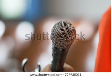 blurred of hands holding businesspeople speaking with microphones in seminar, talking speech at conference hall with bokeh light background.
