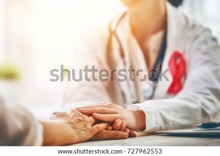 Pink ribbon for breast cancer awareness. Female patient listening to doctor in medical office. Support people living with tumor illness. Royalty-Free Stock Photo #727962553