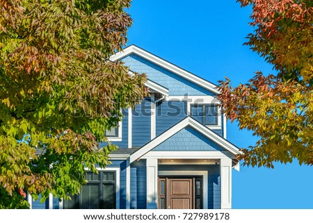A perfect neighborhood. Houses in suburb at Summer in the north America. Fragment of a luxury house with nice window over blue sky.