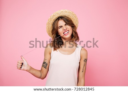 Portrait of a funny crazy girl in summer playing with chewing gum isolated over pink background