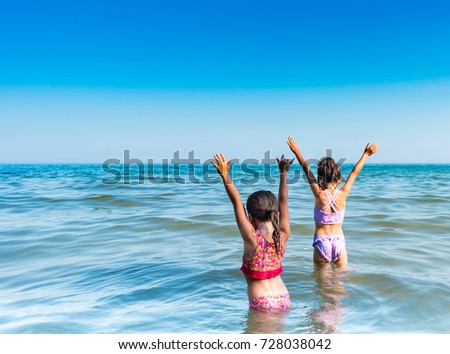 Girls with outstretched arms swimming in Lake Ontario