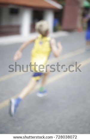 Blurred motion or action of school kid, child,boy running,sprint,compete,marathon,cross country to win for sport race competition. Photo is blurred and meant to see only movement and action.