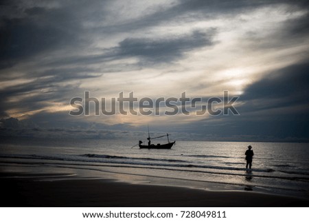 Silhouette picture of fishing boat and fisherman at sun rise in the morning