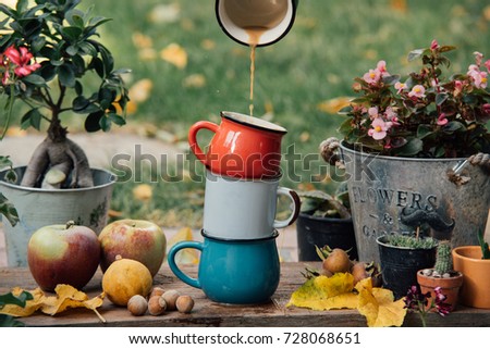 Close up view of pouring coffee in  a mug. Bright colors. Autumn decoration

