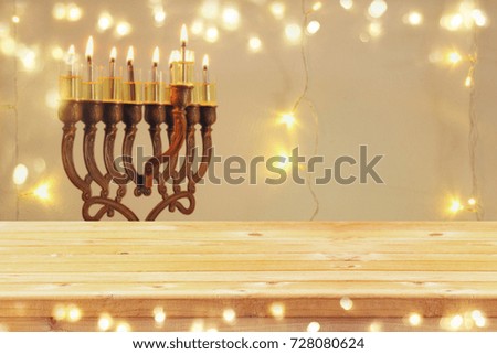 Empty wooden table in front of jewish holiday Hanukkah background with menorah (traditional candelabra). For product display