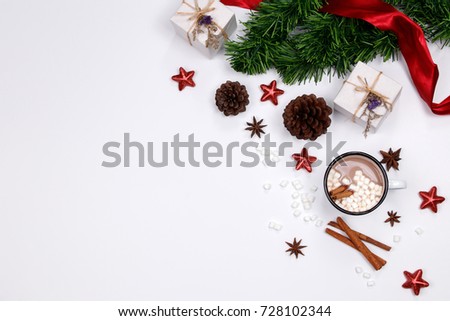 Cup of hot Chocolate drink with marshmallows, cinnamon sticks, anise star, gift and cones on white background. Winter christmas holiday background. Flat lay, Top view.