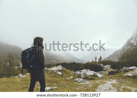 One man hiking up the mountain and looking at view of Julian Alps, outdoors lifestyle