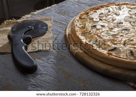 Italian Delicious Fresh Hot Mix Baked Pizza with Melting Cheese, sliced mushrooms , tomato sauce and cheddar serving on grey textured rustic background.