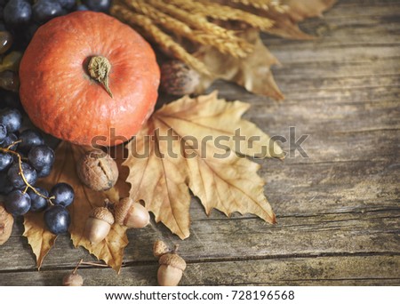 Happy thanksgiving holiday concept. Top view of autumn leaves, pumpkin, and fruits on rustic wooden table with copyspace.
