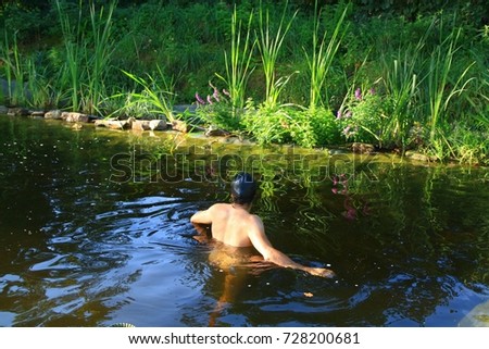 A young man enjoy bathing in a natural swimming garden pond Royalty-Free Stock Photo #728200681