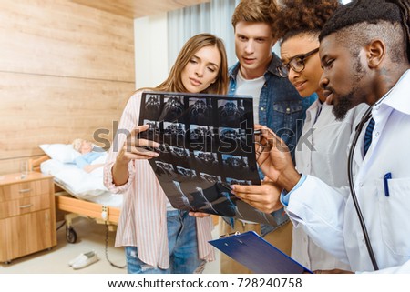 Group of doctors and patients examining X-ray photograph in a hospital room