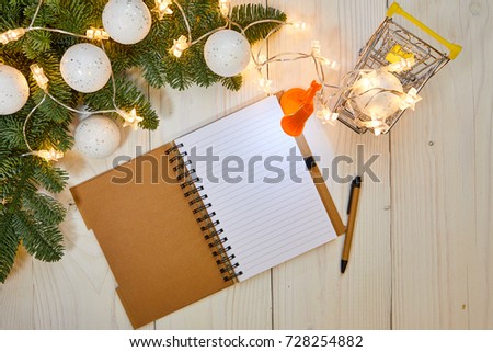 Paper sheet on old wooden background, top view, Christmas shopping list