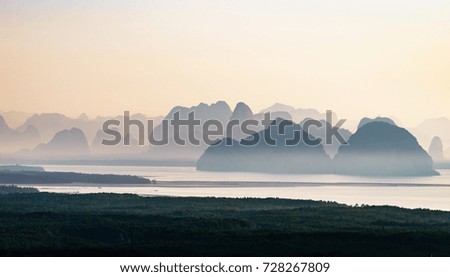 An gentle foggy swims around mountain and mangrove forest at Phang Nga bay, Thailand, silhouette picture