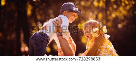 Parents hold their smiling children up