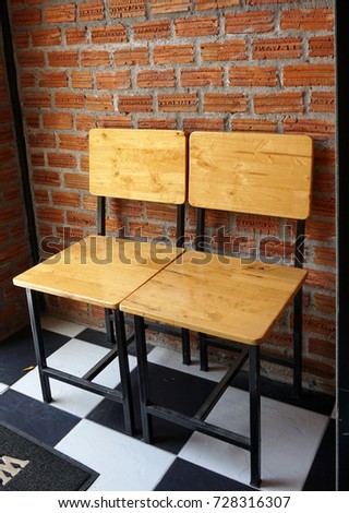 Beautiful chairs with red bricks background on ceramic tile floor