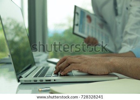 Businessmen use laptops to present reports to the chief,Close up business man use laptop Selective focus on hand.
