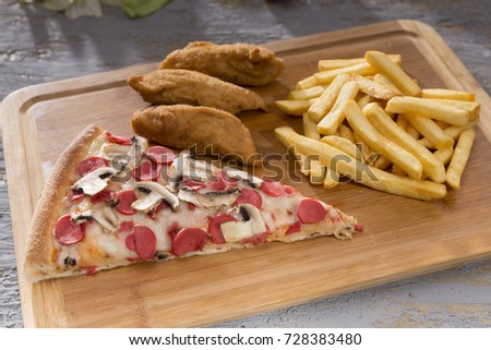 Delicious Baked Italian Homemade Pizza slice ingredients sliced sausage, mushroom, special tomato sauce, melted mozzarella cheese serving with golden french fries and fried chicken tender nuggets.