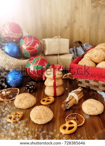 Biscuits with cinnamon surrounded by present boxes and Christmas attributes on a wooden background. Photo with special editing