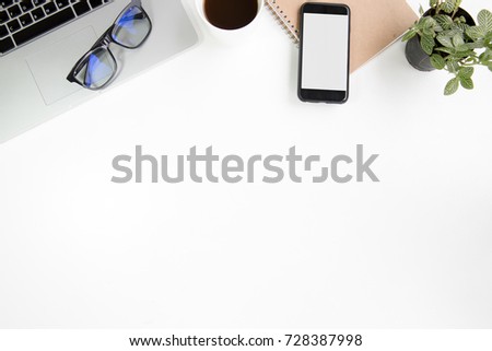 work space office desk table top header layout on top have laptop , coffee cup, notebook, glasses, plant, smart phone modern style on white table in company