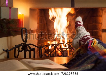 A woman in warm socks in front of a fireplace. Relax