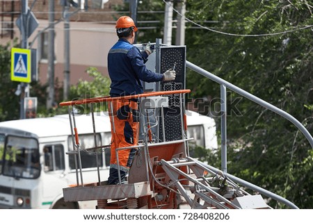 Installation of a traffic light on a lift in the afternoon in the city