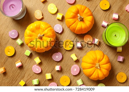 Pumpkin Halloween concept with candy, candle on wooden table