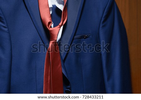 men's blue jacket with an orange tie