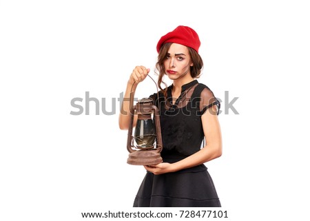 Studio portrait of young woman in Halloween costume posing with lantern