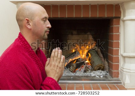 young man meditating near the fireplace