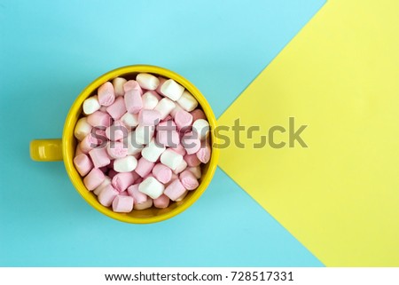 top view yellow cup with marshmallows on bright background