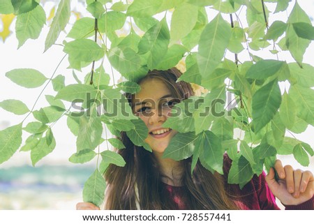 Young blonde girl enjoys a sunny day in autumn, golden yellow foxes around, smile on face, relaxation, autumn, foliage falls off branch