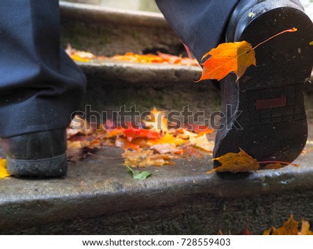 Autumn leaf on shoes. Autumn leaf on shoes men climbing the stairs.