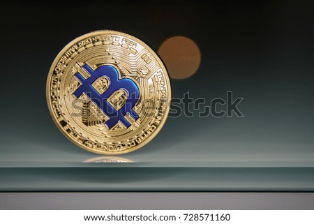 golden bitcoin standing on glass
