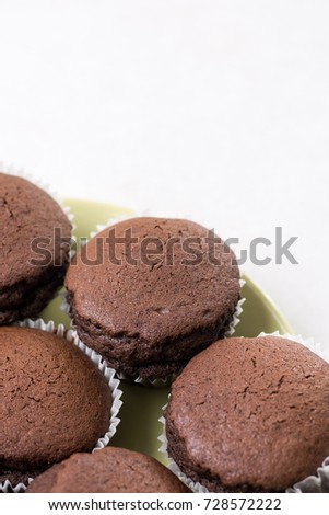 Flat lay above chocolate cup cakes on the white marble background with copy space.
