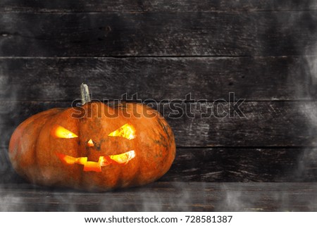 Spooky Halloween pumpkin head jack lantern on wooden background