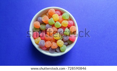 Colorful jujubes on blue background top view