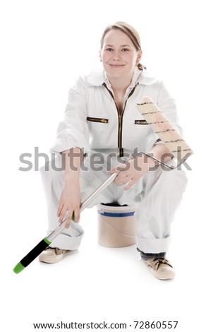 Cheerful young woman with long blond hair wearing a white overalls. She is holding a paint roll in her hand, isolated against a white background.