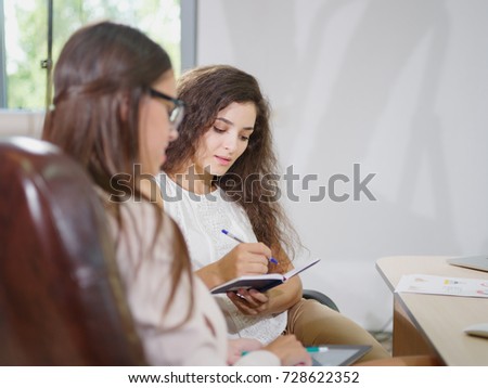 Two young, beautiful business women in the office.