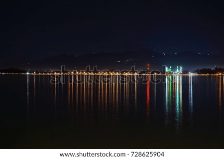 Cityscape night view with reflection on water.