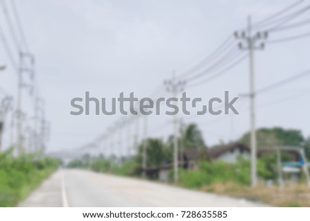 Blurred Electric street pole with road.
