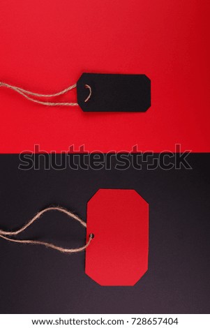 Black tag on a red background and a red tag on a black background.