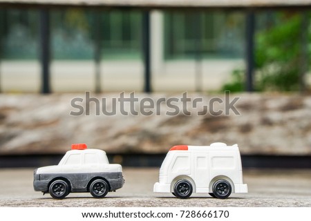 transportation concept - cute police car and ambulance van toy model on wooden bench for kid