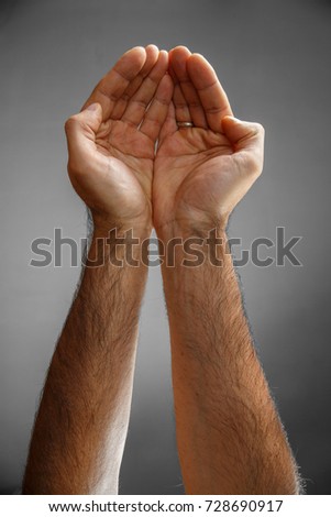 hands on a gray background. palms hold something